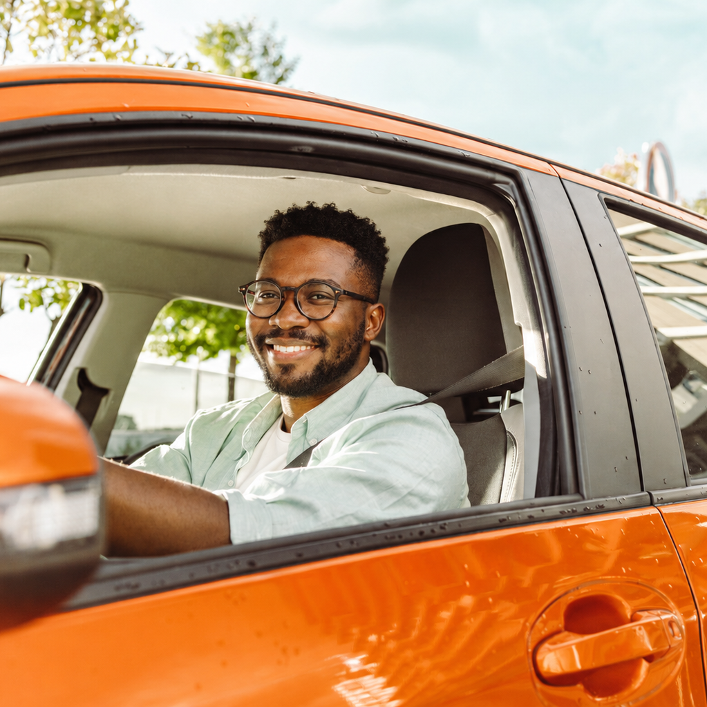 Motorista sorrindo ao volante do seu carro